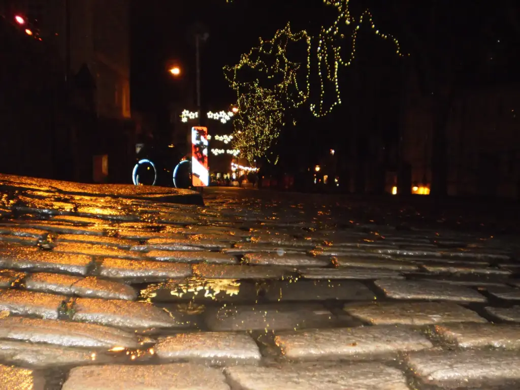 Calle adoquinada de Marburgo, en Alemania, brillante de agua después de llover
