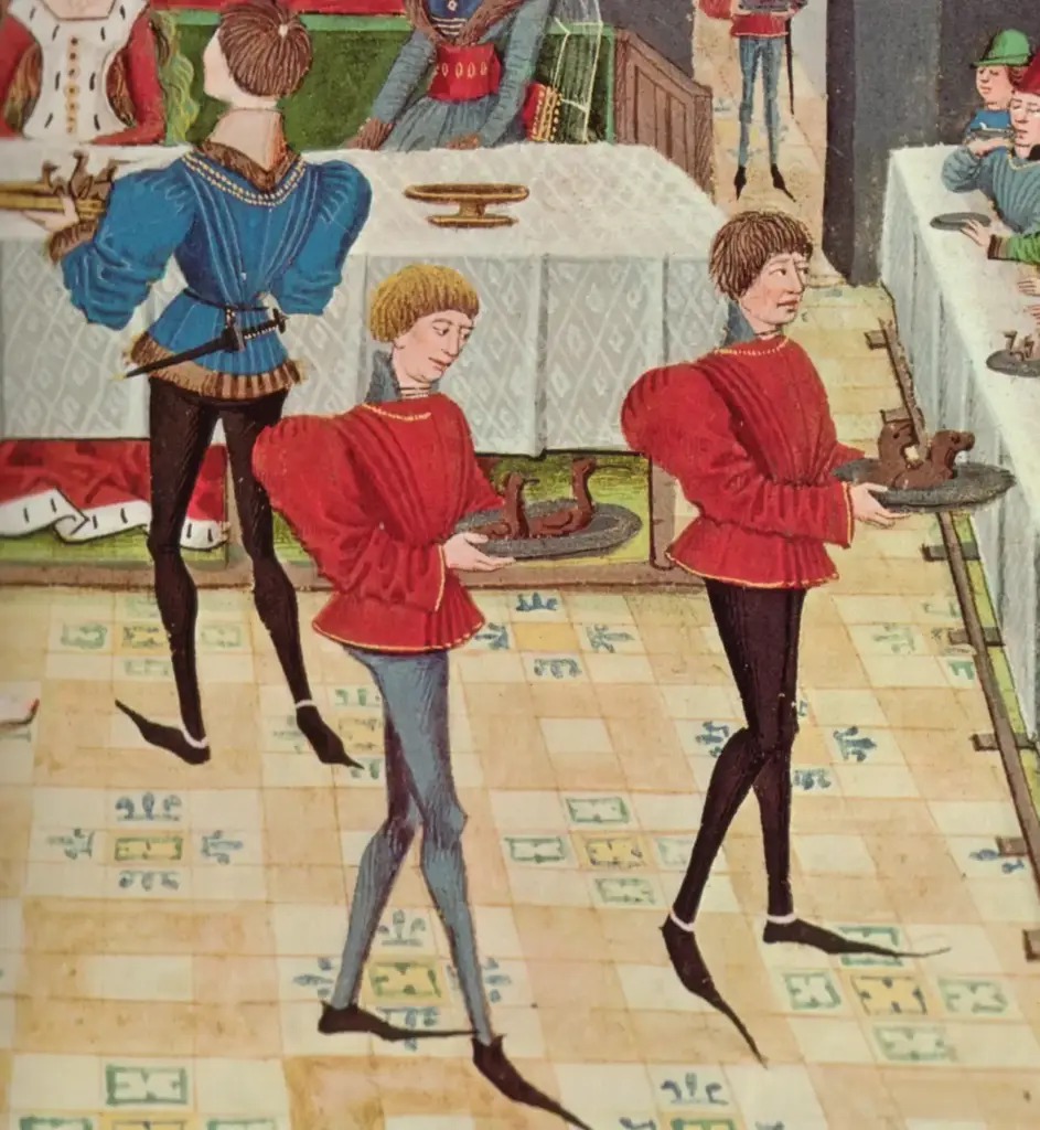 Criados con poulaines sirviendo un banquete, en una miniatura de un manuscrito de Renaud de Montauban de hacia 1467-1469
