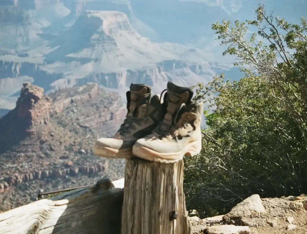 Botas de montaña colgadas sobre un poste de madera ante el Gran Cañón del Colorado