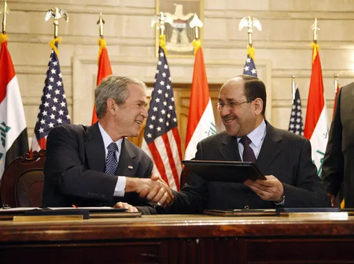 El presidente George W. Bush y el primer ministro iraquí Nuri al Maliki se dan la mano en Bagdad el 14 de diciembre de 2008, el día del lanzamiento de zapatos