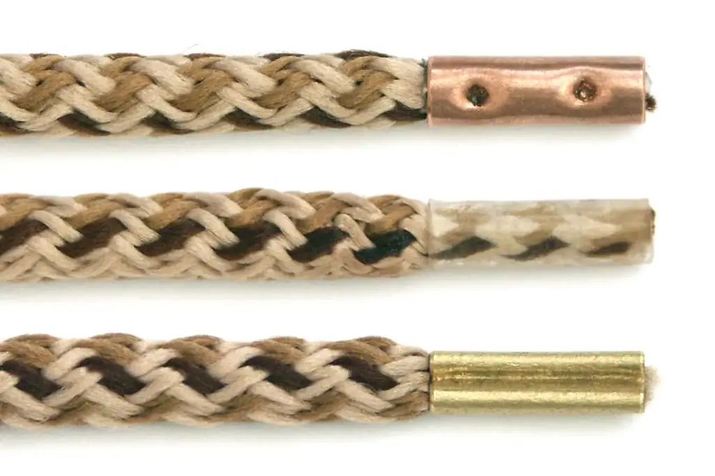 Three identical shoelaces tipped with three different aglets: copper, plastic and brass