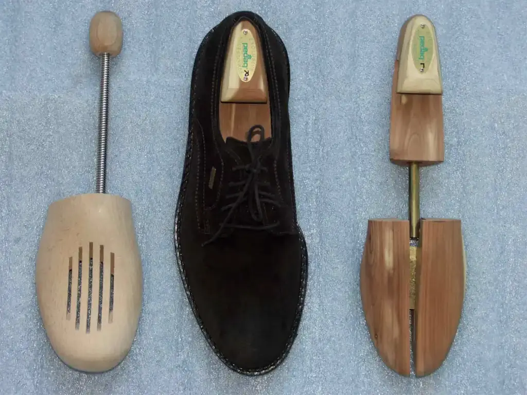 Zapato de ante con hormas de madera para guardarlo, una de ellas de cedro con muelle