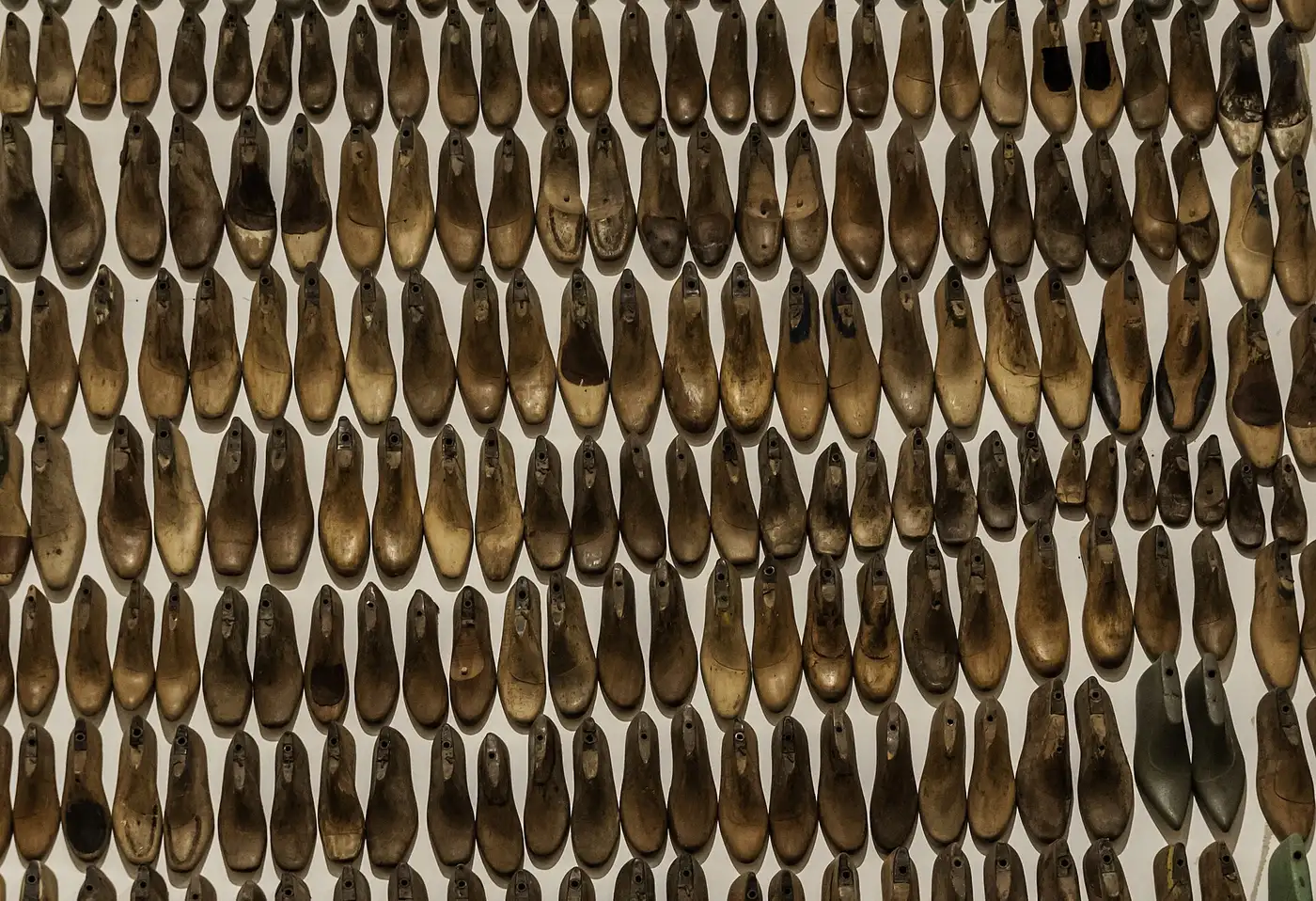 Decenas de hormas de madera para zapatos colgadas en una pared del Museu Afro Brasil