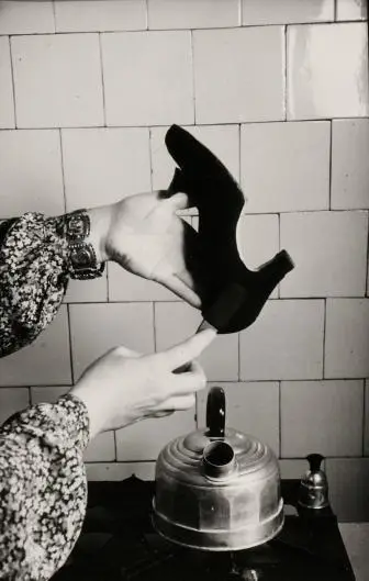 Suede shoes being brushed and cleaned over the steam from a teakettle in the Netherlands, between 1950 and 1960
