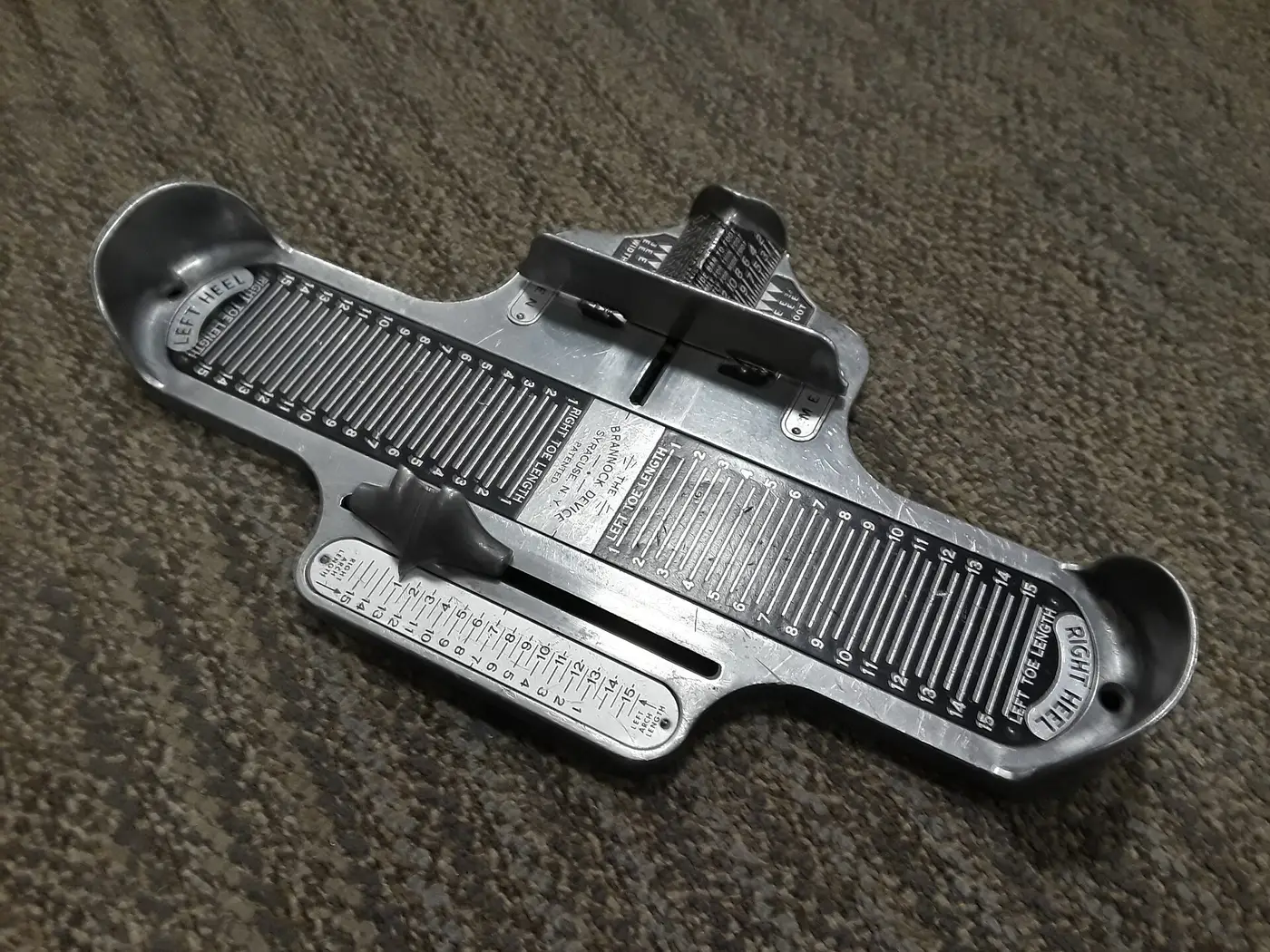 Medidor Brannock de metal para medir el largo y el ancho del pie en una zapatería