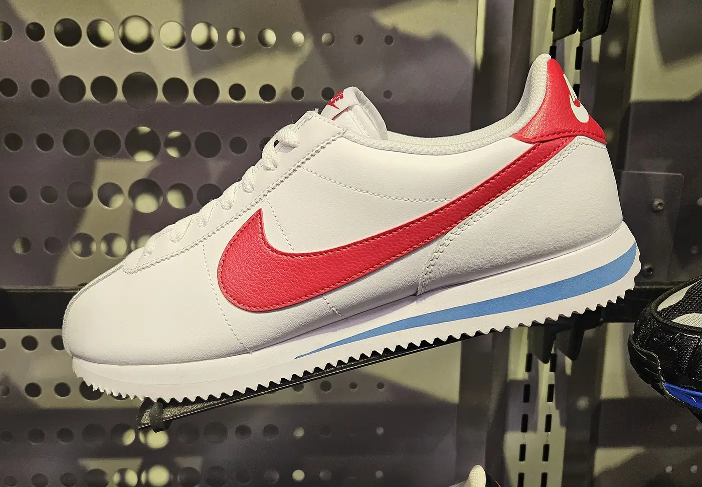 Zapatilla Nike Cortez blanca con el logotipo rojo, vista de lado
