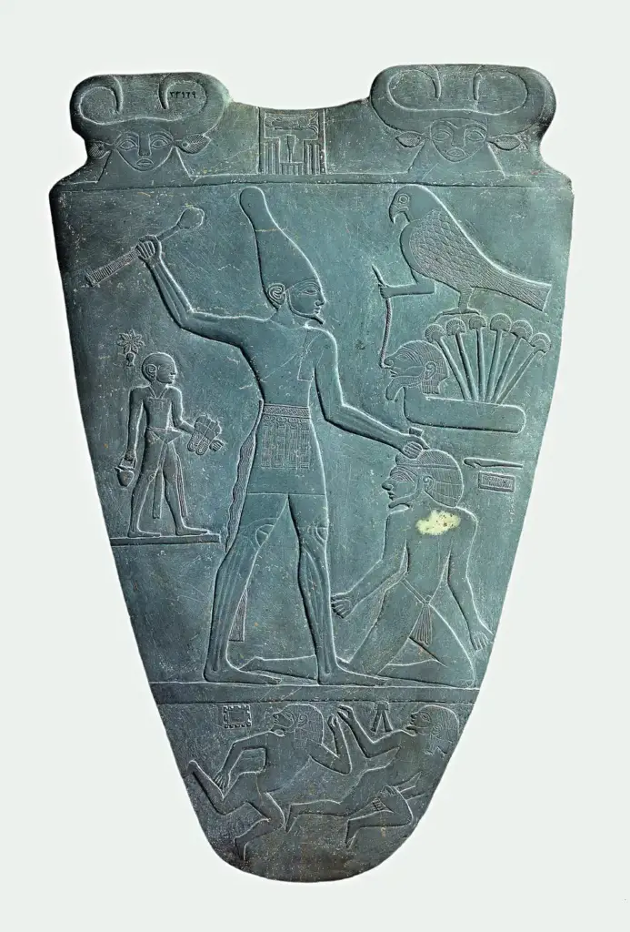 Cara de la Paleta de Narmer en la que el rey golpea a un prisionero mientras un sirviente, detrás de él, lleva sus sandalias
