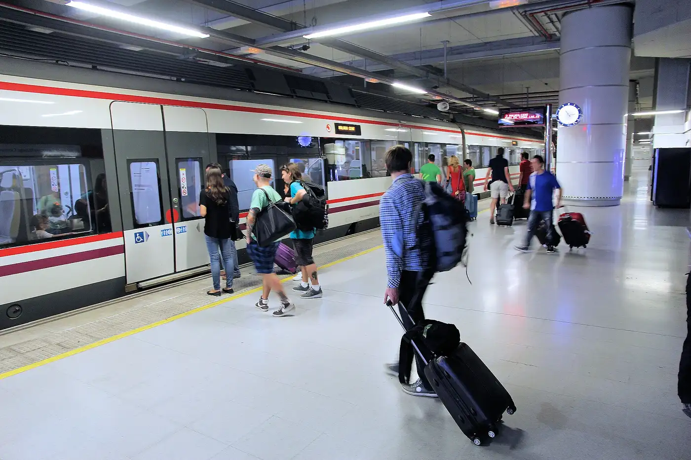 Pasajeros con maletas de mano subiendo al tren en la estación del aeropuerto de Málaga
