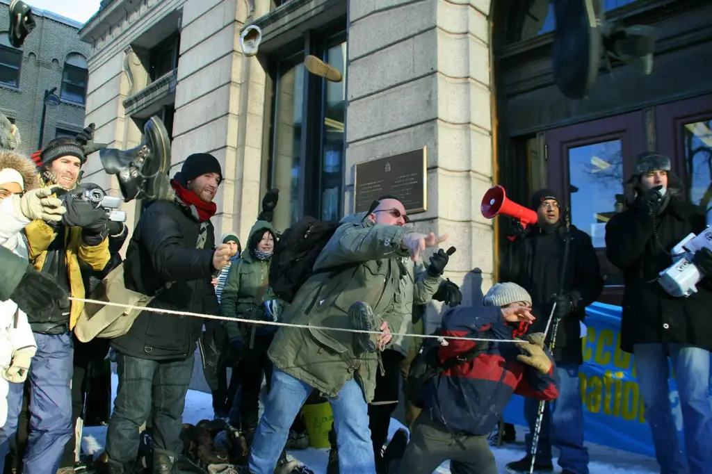 Manifestantes lanzando zapatos contra un cartel de George W. Bush delante del consulado de Estados Unidos en Montreal el 20 de diciembre de 2008