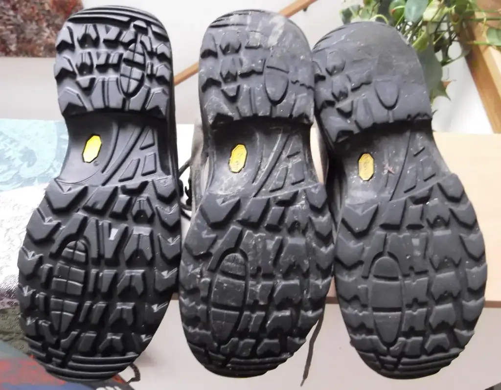 Tres suelas del mismo modelo de calzado de montaña con distinto desgaste en los tacos, de más nuevo a más gastado
