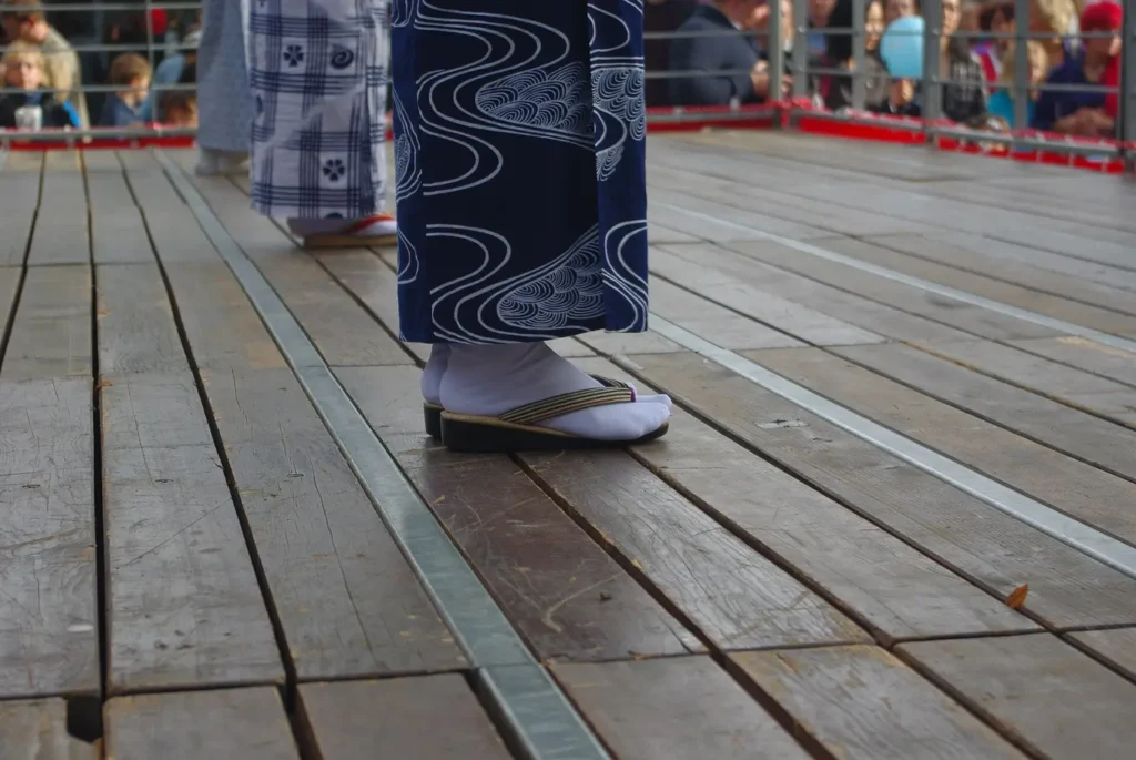 Tabi blancos con zori bajo un kimono, en un festival japonés