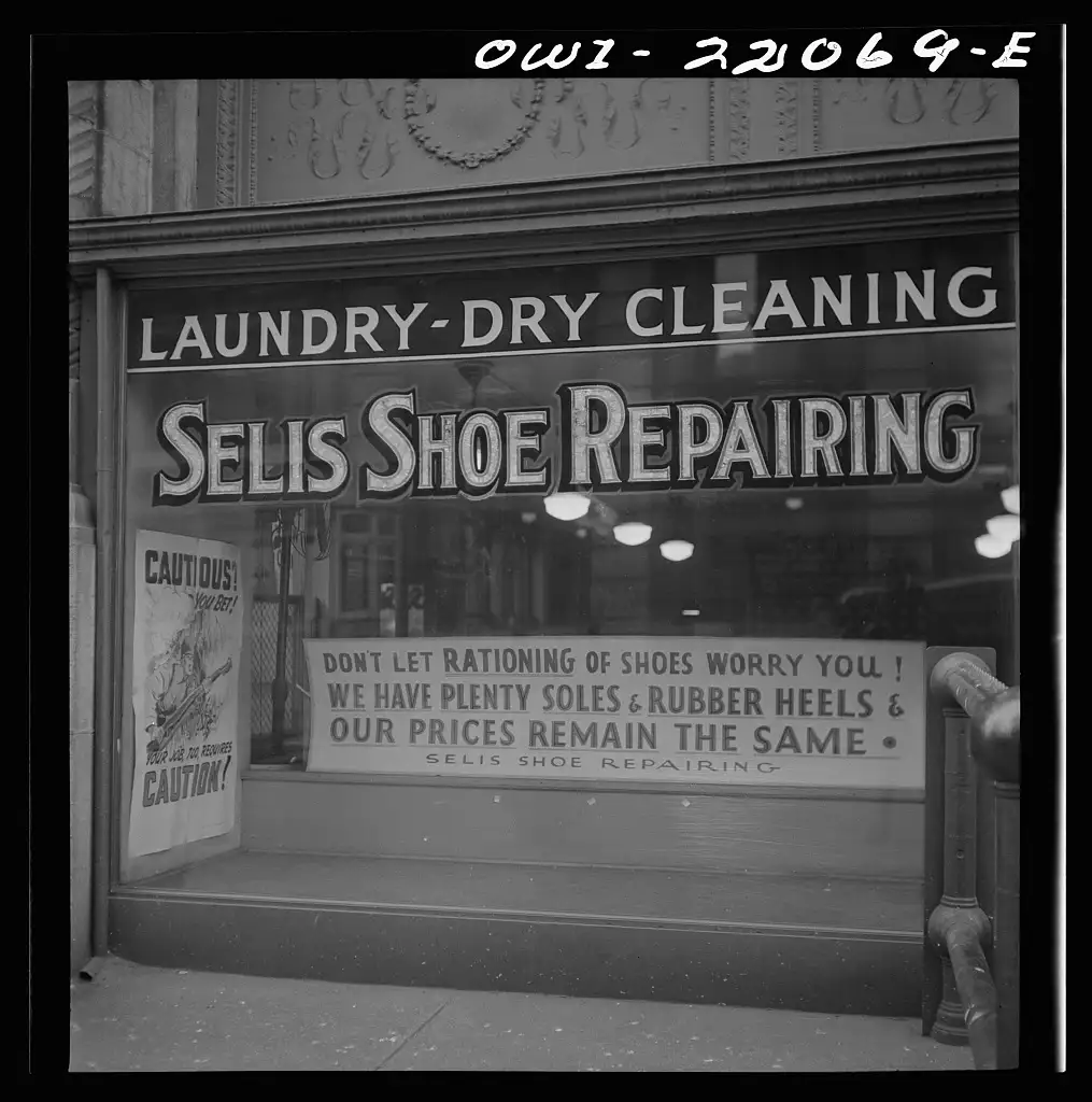 Escaparate de un taller de reparación de calzado en 1943, con un cartel que anima a no preocuparse por el racionamiento de zapatos porque hay suelas y tacones de goma de sobra