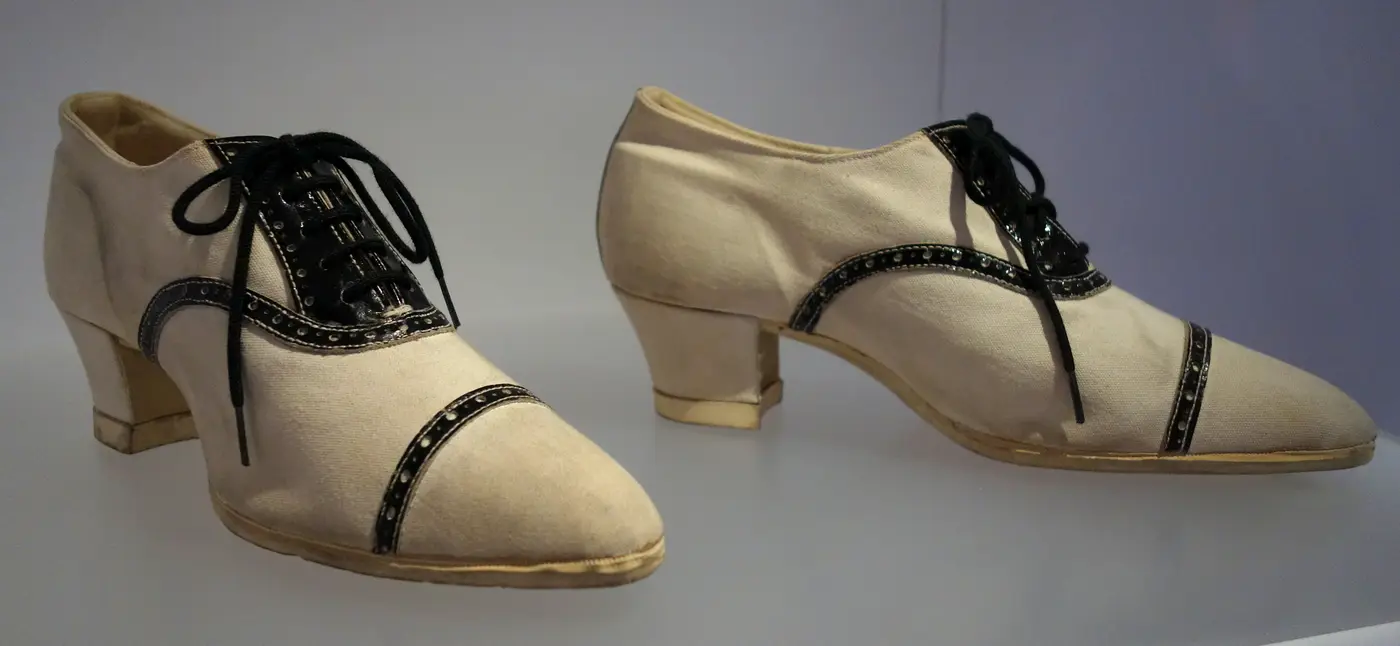 Zapatillas de lona blanca con tacón y cordones negros de hacia 1925, expuestas en el Bata Shoe Museum de Toronto