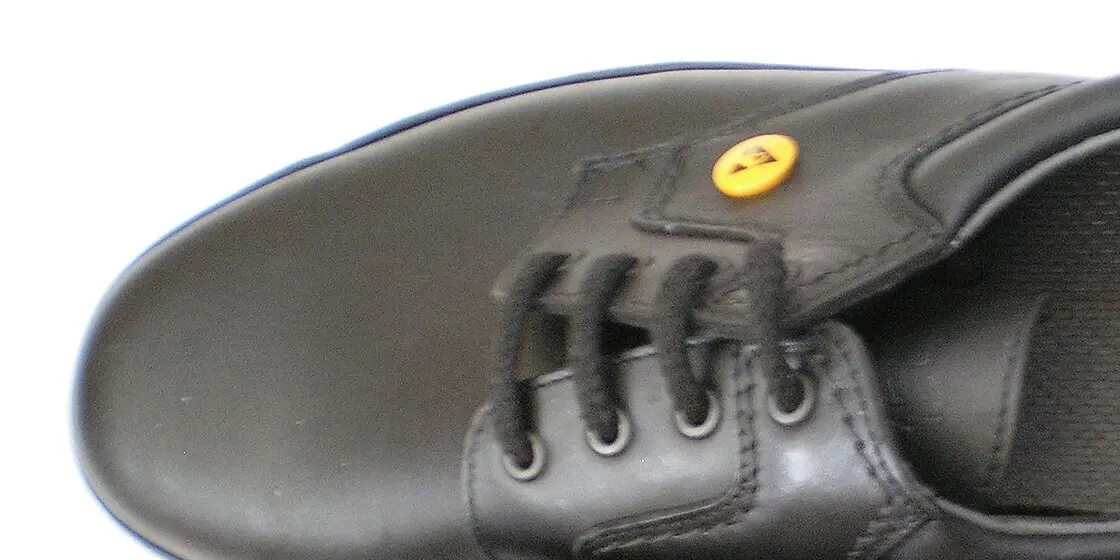 Zapato de trabajo negro con un distintivo ESD amarillo en el empeine