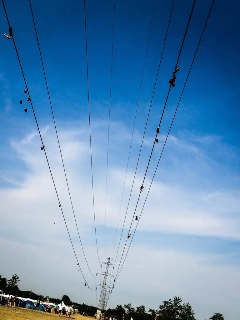 Dozens of shoes hanging from the wires of a 132,000-volt power line at the Roskilde Festival in Denmark