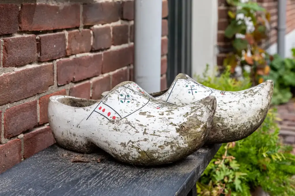 Un par de zuecos de madera holandeses pintados, sobre un banco de una calle de Veere, en Zelanda